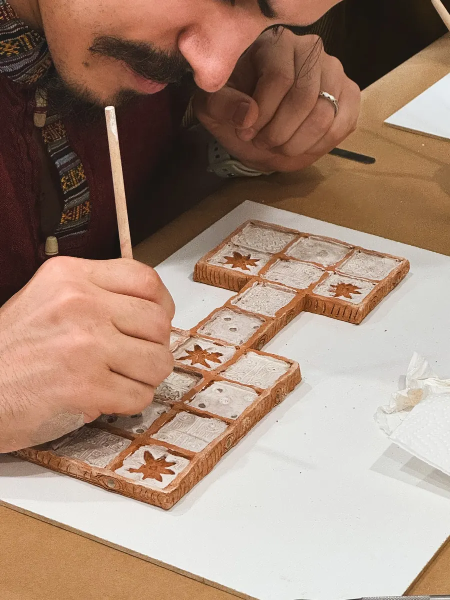 Cursant pictând un obiect de ceramică